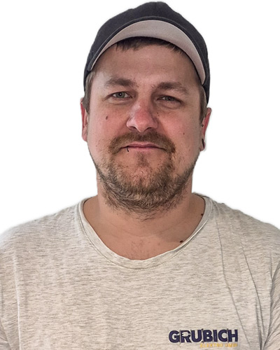 Mann mit schwarzer Kappe und hellgrauem T-Shirt mit aufgedrucktem Schriftzug 'GRUBICH'